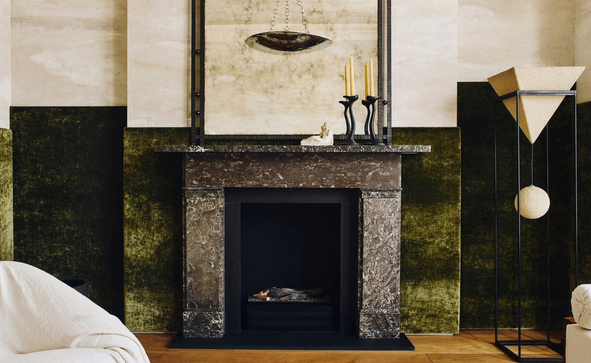 Olive velvet living room with marble fireplace and antiqued mirror at Tala Fustok Studio