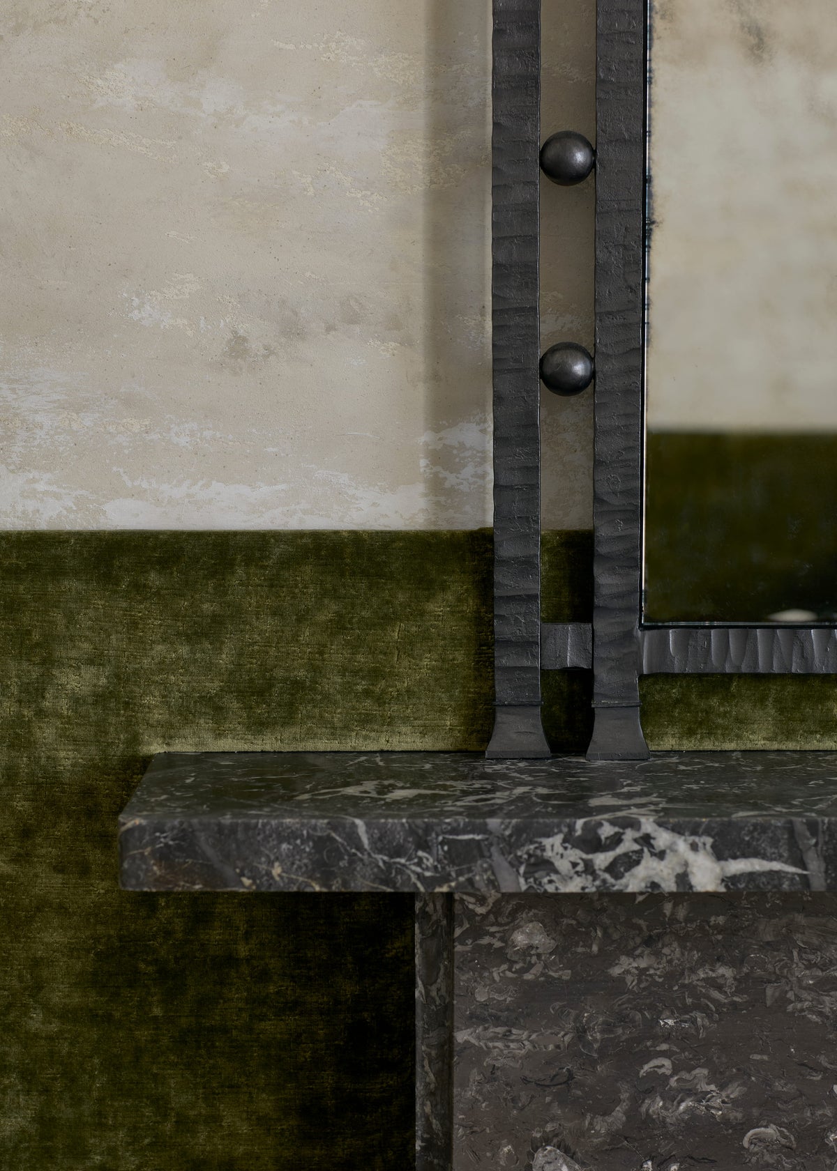 Detail of Gaze’s hammered blackened steel frame with round studs, meeting a marble mantel