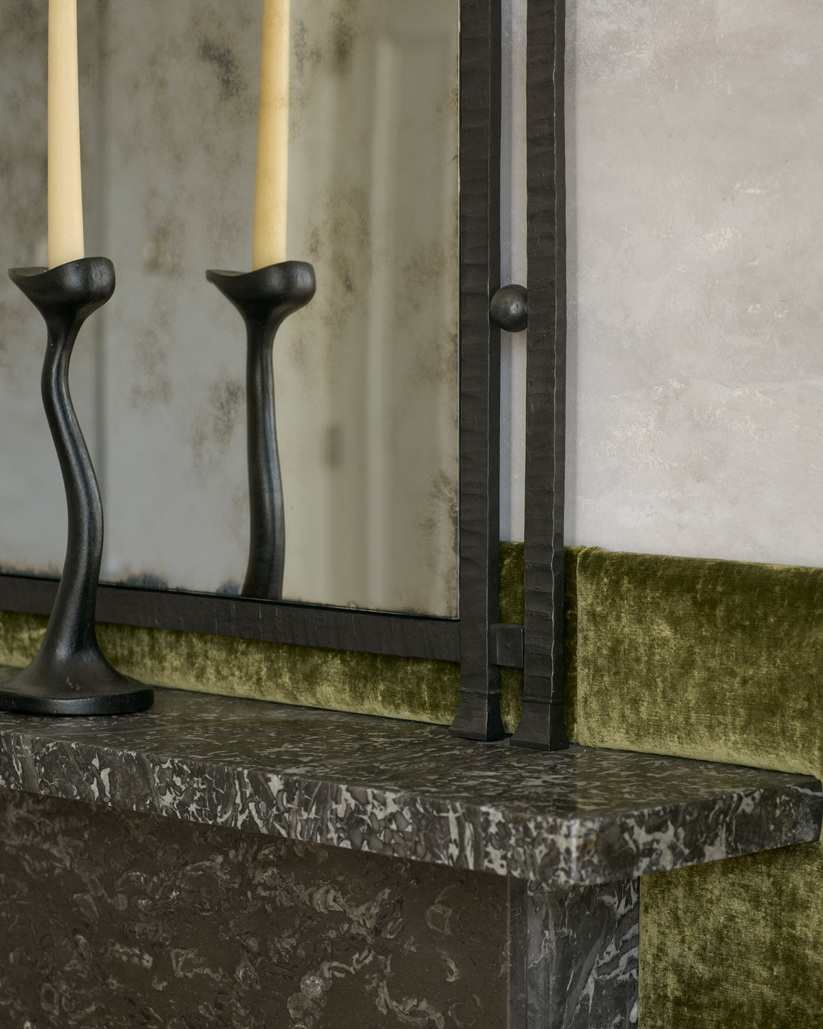 Close-up of Gaze’s textured steel frame beside a black candlestick on a marble mantel