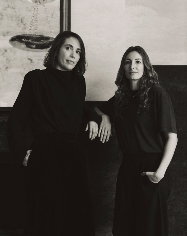 Black-and-white portrait of Tala Fustok Studio founders in minimalist black attire