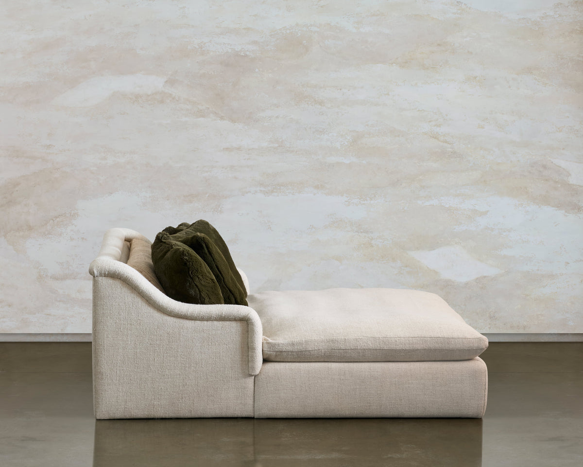 Side profile of Lazy Sunday, showing the low cream seat and piled olive cushions