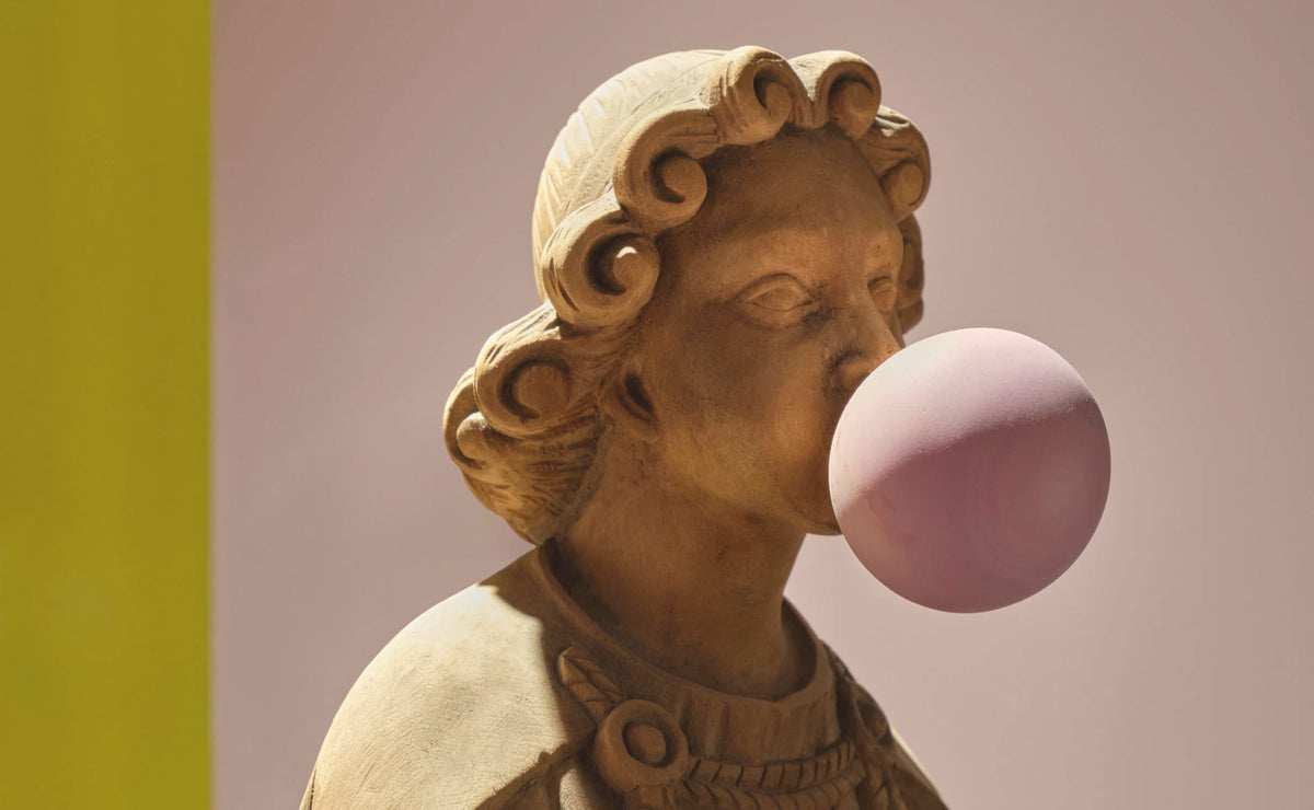 Classical terracotta bust blowing a pink bubblegum bubble at CoOc Members Club by Tala Fustok Studio