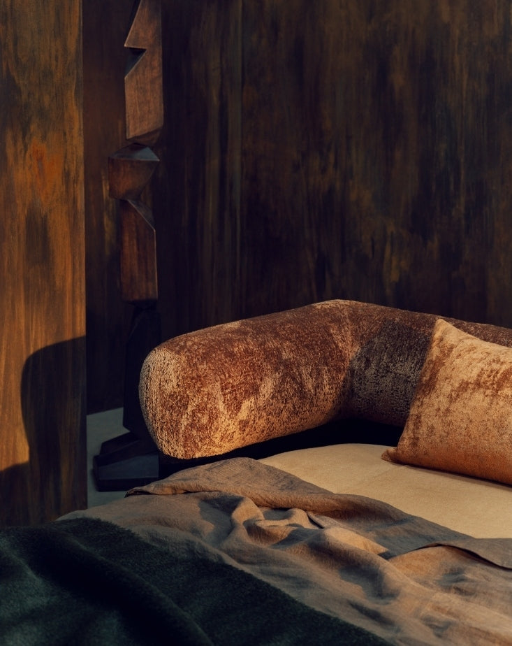 Rust-toned daybed with patinated bronze wall panels from Tala Fustok Studio