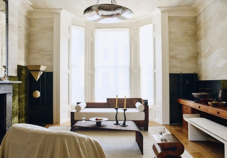 Living room with a burl-wood daybed in a bay window in the Ladbroke Grove apartment by Tala Fustok Studio