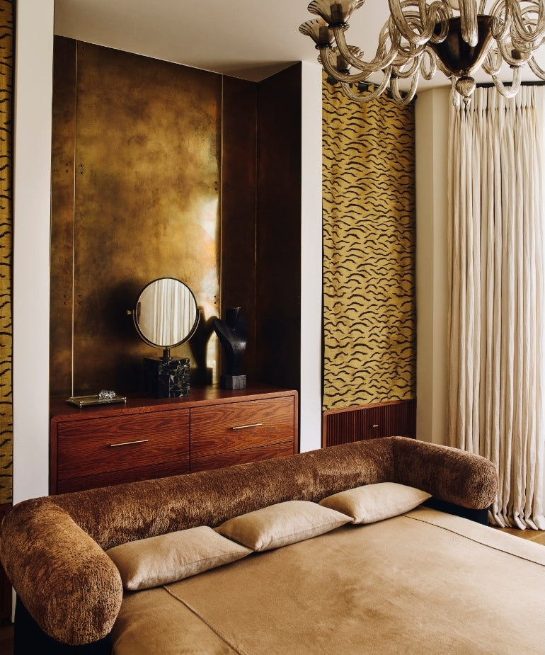 Bedroom with a chocolate velvet bolster headboard and brass-panelled alcove in the Ladbroke Grove apartment