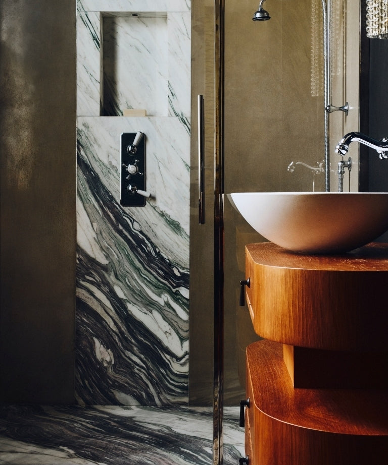 Bathroom with green marble, a two-tier wood vanity, and a glass shower in the Ladbroke Grove apartment