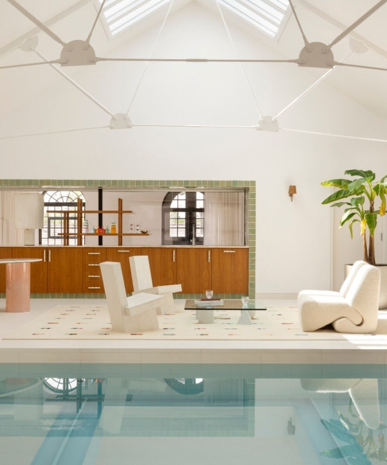 Indoor pool and lounge with a vaulted ceiling in the North London warehouse by Tala Fustok Studio