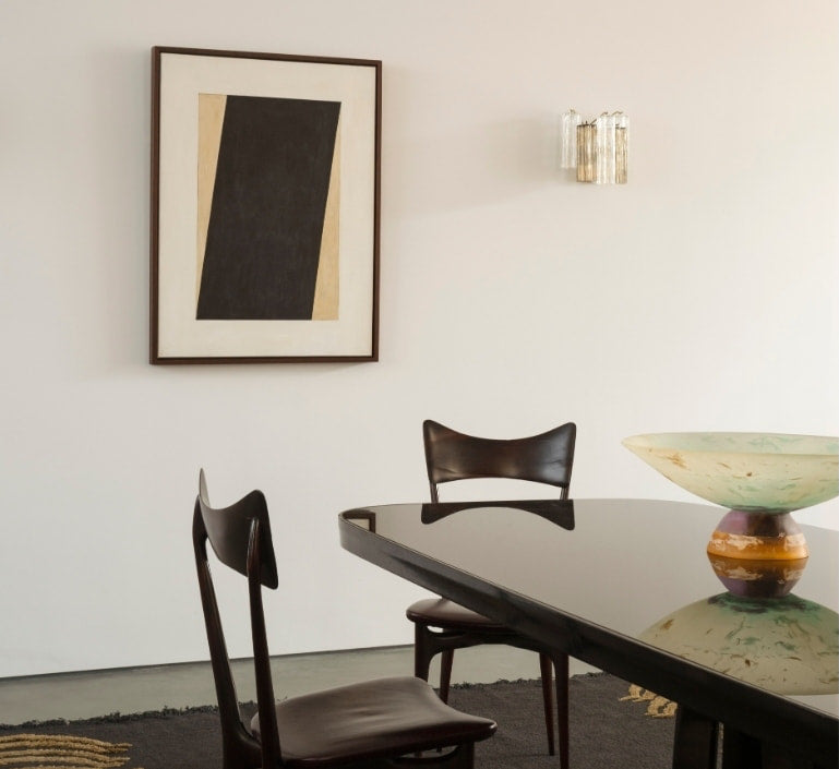 Dining table with sculptural wood chairs and abstract art in the North London warehouse by Tala Fustok Studio