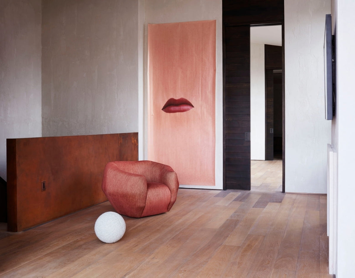 Sculptural coral armchair beside red lips artwork in the New York SoHo apartment by Tala Fustok Studio