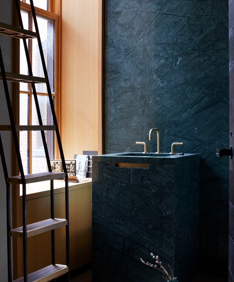 Monolithic dark green marble vanity with brass fittings in the New York SoHo apartment by Tala Fustok Studio