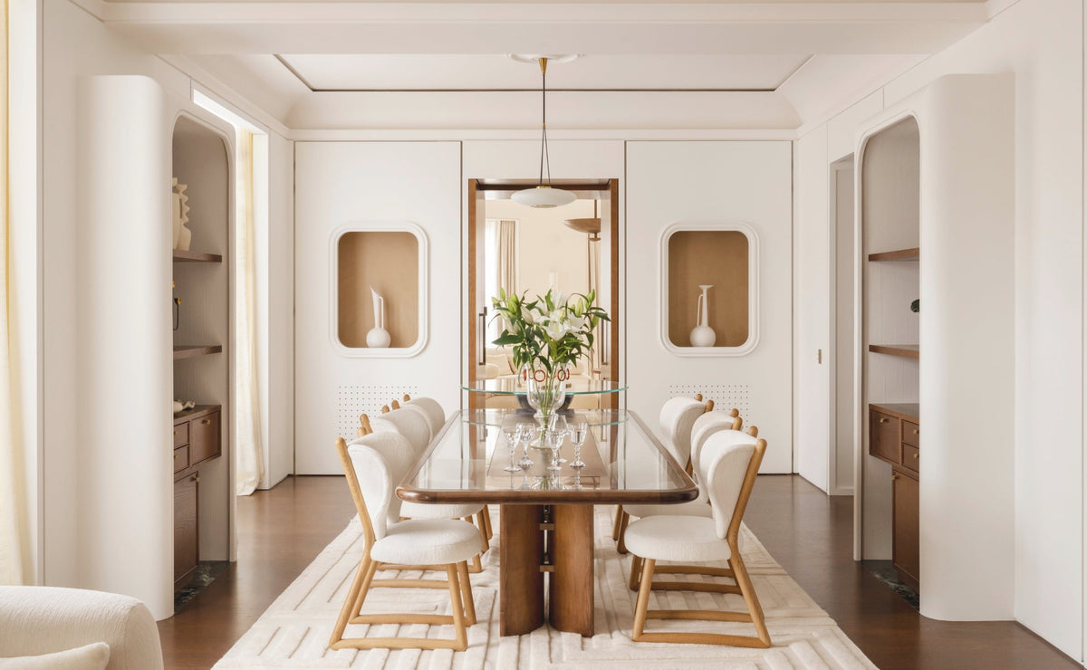 Dining room with a dark wood table, white chairs, and arched wall niches in the Paris 16th apartment