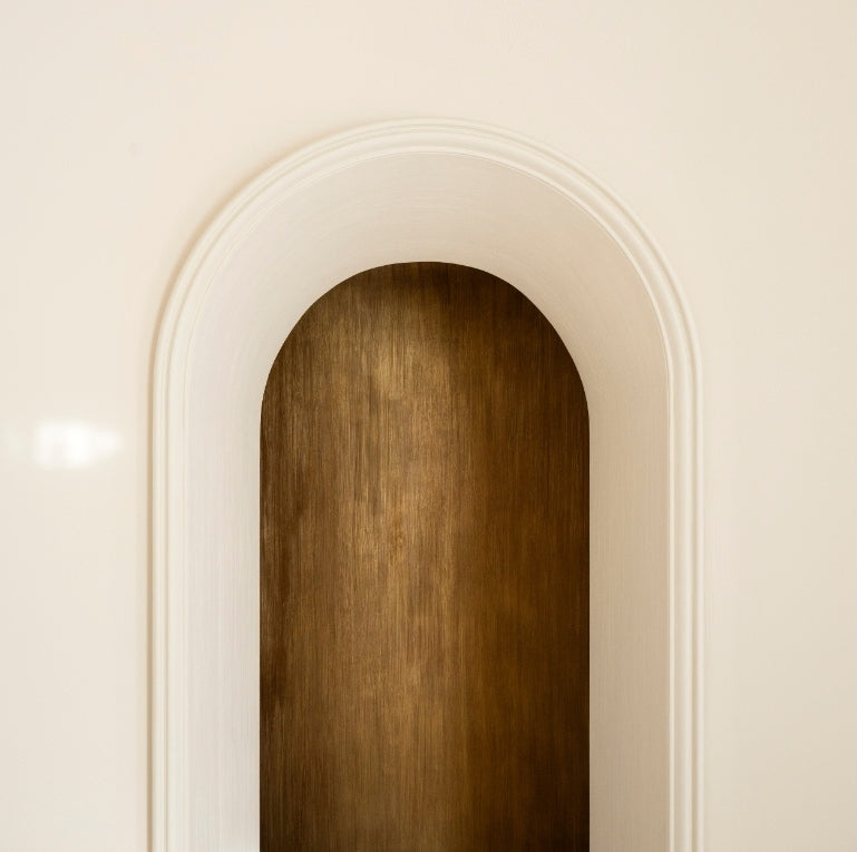 Layered arched niche with a patinated bronze panel in the Paris 16th apartment by Tala Fustok Studio