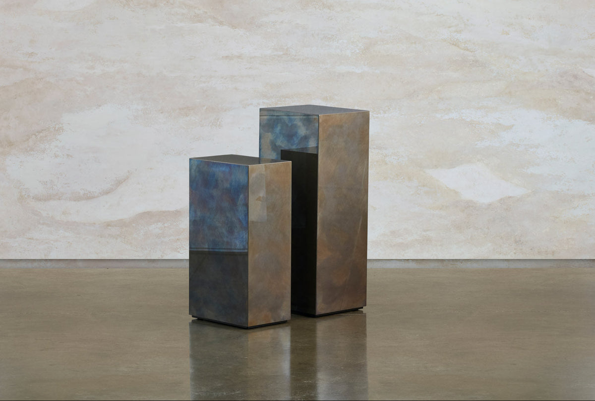 Two Tandem stainless steel blocks by Tala Fustok Studio, one short and one tall, with a blue and bronze patina