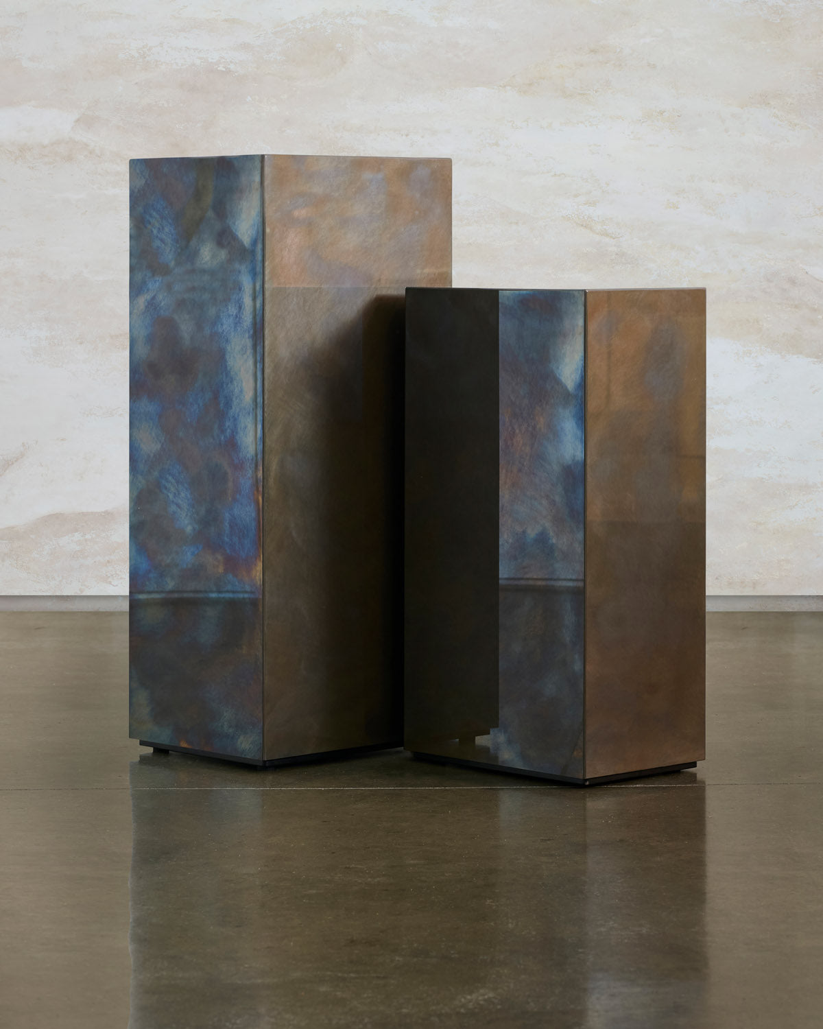 Close pairing of two tall Tandem blocks, one with a blue patina and one in darker bronze steel