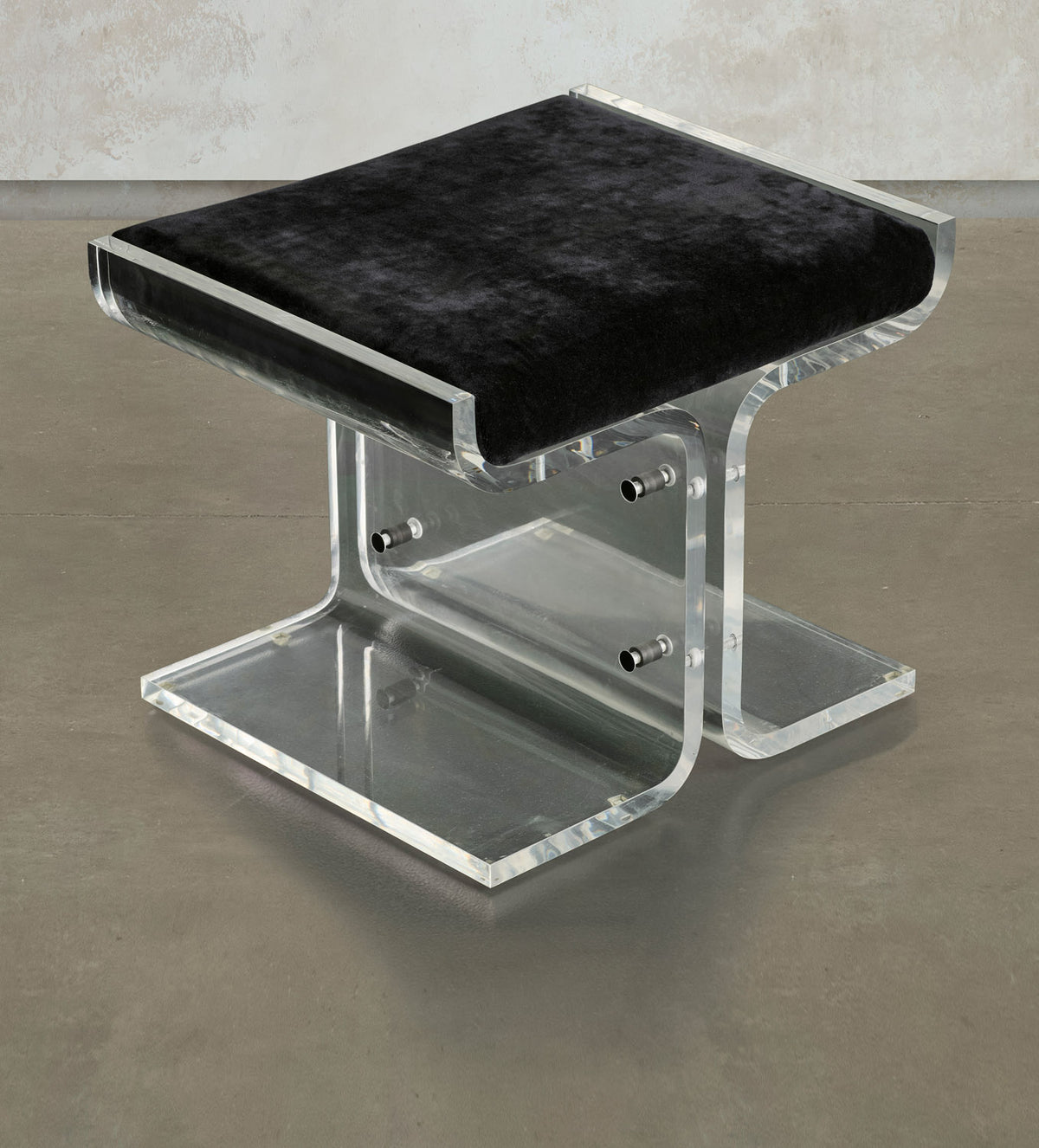 Three-quarter view of Trace, showing the velvet seat, curved Lucite supports, and metal bolts