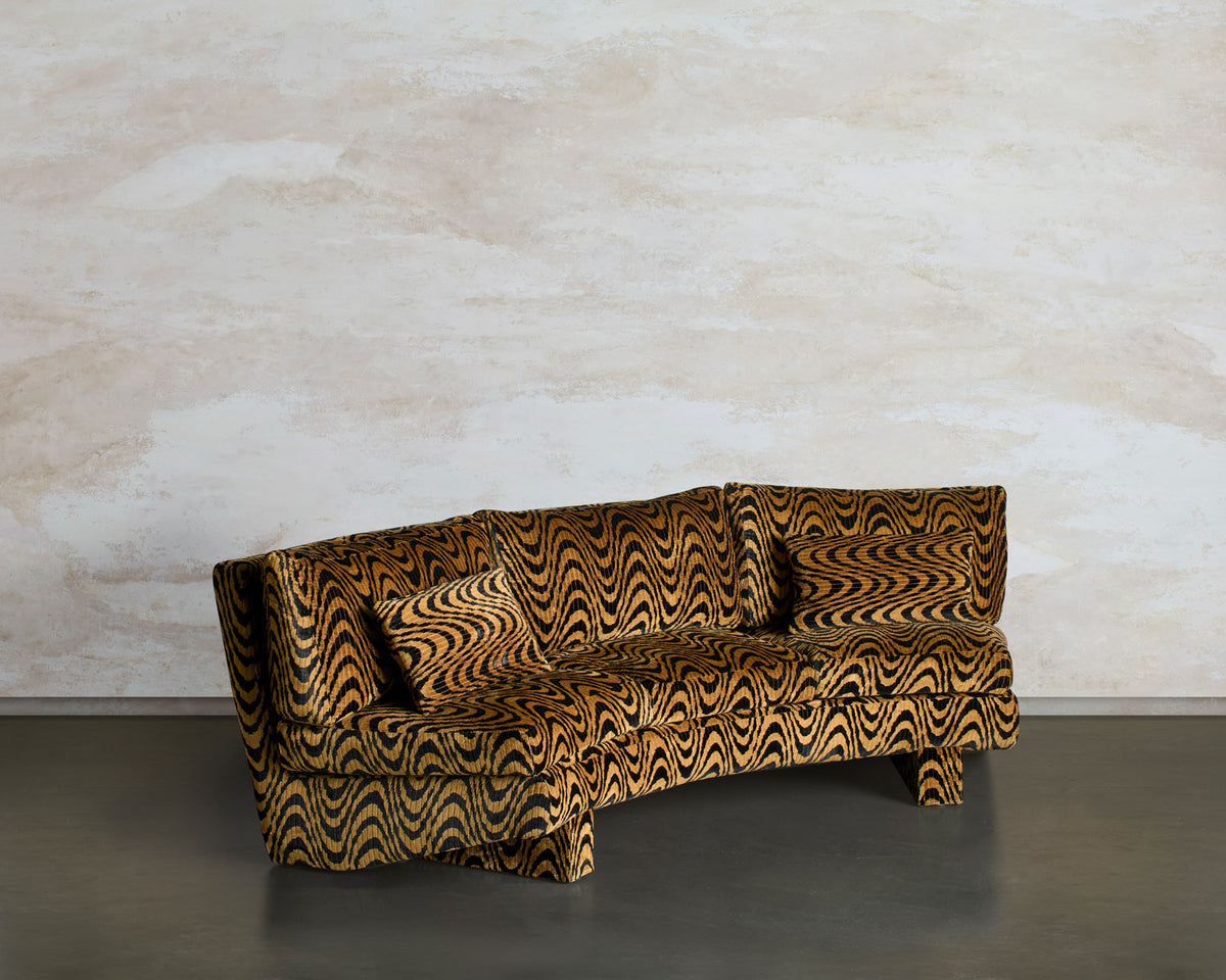 Angled view of the Tripnotic sofa, showing its curved silhouette and matching cushions